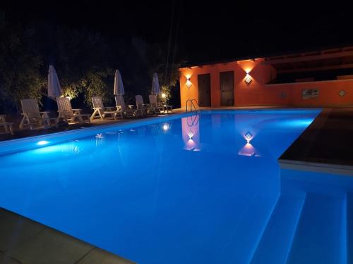 a swimming pool at night with blue lights at Borgomare in Campofelice di Roccella