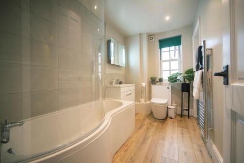 un bagno bianco con vasca e lavandino di Cotswolds period townhouse near Stratford-upon-Avon, central location short walk to pubs, restaurants and shops a Shipston-on-Stour
