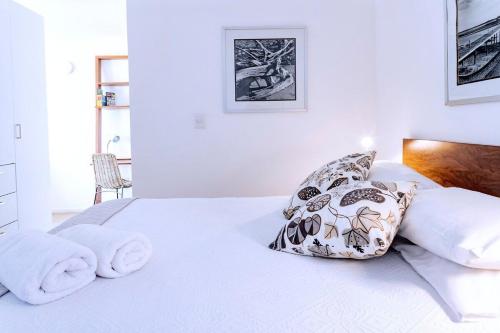 Un dormitorio blanco con una cama con toallas. en 36 Perú Nuevo Moderno Loft en pleno Centro Histórico, en Ciudad de México