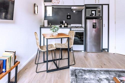 a kitchen with a table and chairs and a refrigerator at Cálido loft a pasos del Zócalo Disfrútalo in Mexico City