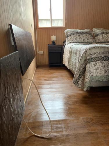 a bedroom with a bed and a television in it at Cabañas Bosque Sur in Puerto Varas
