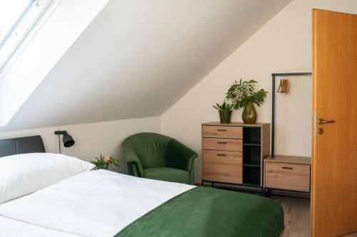 1 dormitorio con 1 cama blanca y 1 silla verde en Ferienhaus Kaiserbaum, en Illmitz