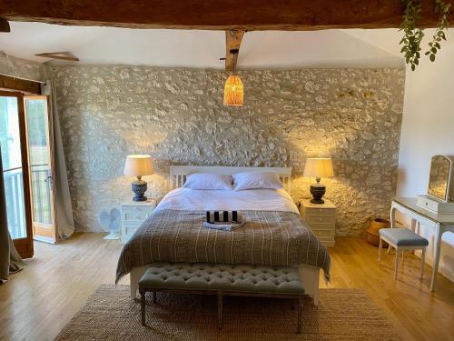 une chambre avec un lit et un mur en pierre dans l'établissement Gorgeous 5 Bed French Farmhouse, à Eymet