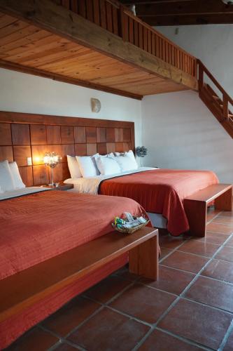 ウアスカ・デ・オカンポにあるTorre del Condeのベッドルーム1室(赤いシーツと階段付)