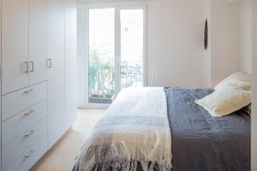 een witte slaapkamer met een bed en een raam bij SUPERMODERNO En Pleno Centro Histórico in Mexico-Stad