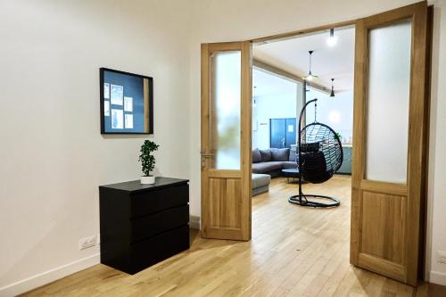 un salon avec une porte s'ouvrant sur un salon dans l'établissement Loft aux portes de Paris - Parking gratuit, à Bagnolet