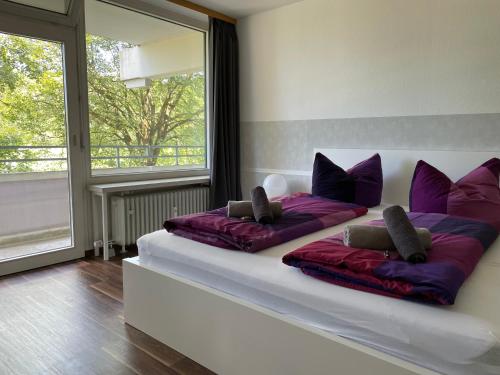 2 łóżka w pokoju z fioletowymi poduszkami w obiekcie Ferienwohnung Bergblick w Füssen