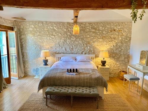une chambre avec un lit et un mur en pierre dans l'établissement Fabulous 9-Bed House in Eymet, à Eymet