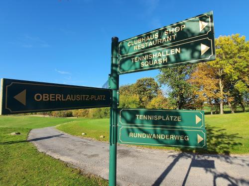 a pole with street signs in a park at Luxusferienhaus Seevilla Monaco am Fleesensee in Göhren-Lebbin
