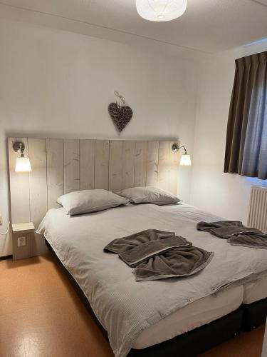 una camera da letto con un letto grande con due accappatoi sopra di Sunset Beach House a L'Aia
