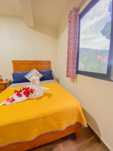 a bedroom with a yellow bed with a window at Departamento Santa Fe (totalmente nuevo) in Taxco de Alarcón