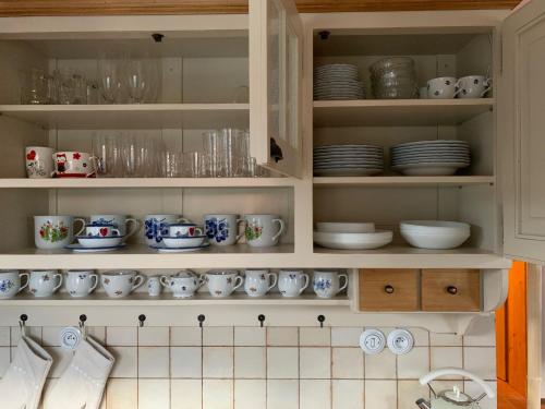 a kitchen cabinet filled with plates and cups and dishes at Roubenka Kokořínsko in Dubá