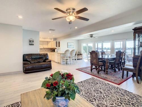a living room with a ceiling fan and a table and chairs at Amazing water front view home newly renovated 3BD 2BTH in Clearwater Beach