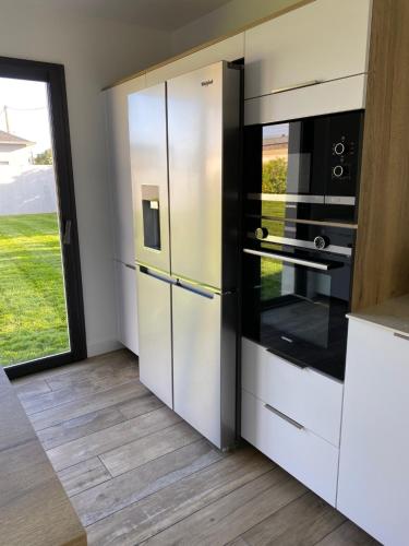 une cuisine avec des armoires blanches et des appareils noirs dans l'établissement L'Offshore, à Penmarcʼh