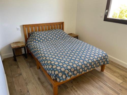 Ce petit lit se trouve dans un dortoir doté d'un couvre-lit. dans l'établissement L'Offshore, à Penmarcʼh