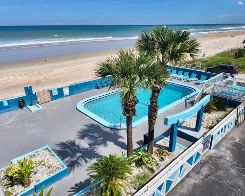 uma vista superior de uma piscina ao lado de uma praia em Chateau Mar Beach Resort em Ormond Beach