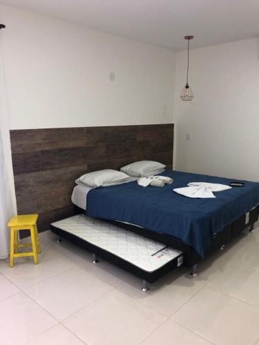 łóżko z niebieskim kocem i żółtym stołkiem w obiekcie Solar da Praia Pousada w mieście Arraial do Cabo