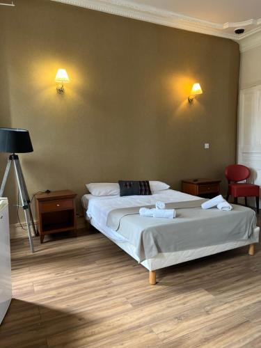 1 dormitorio con 1 cama, 2 mesas y 1 lámpara en Hotel Savoy, en Aix-les-Bains