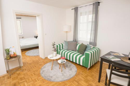 a living room with a green couch and a table at Zum Grazer Uhrturm in Graz