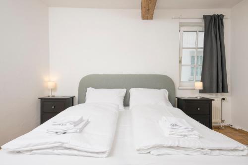 a bedroom with two beds with white sheets and a window at Zum Grazer Uhrturm in Graz