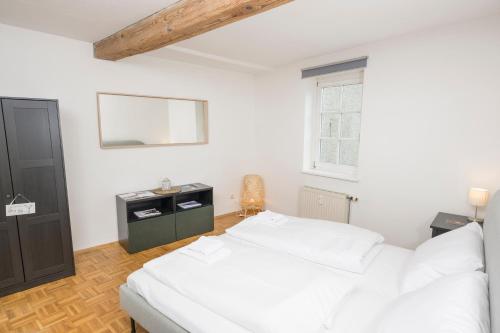 a bedroom with a white bed and a window at Zum Grazer Uhrturm in Graz