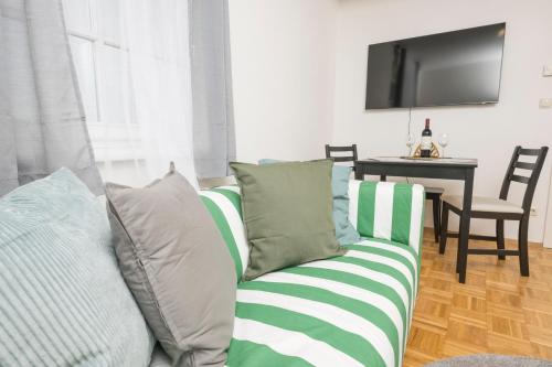 a living room with a green and white couch at Zum Grazer Uhrturm in Graz