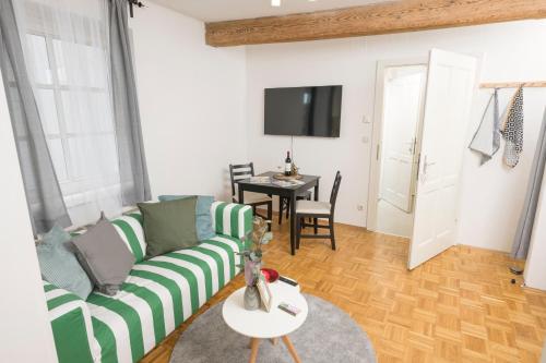 a living room with a couch and a table at Zum Grazer Uhrturm in Graz