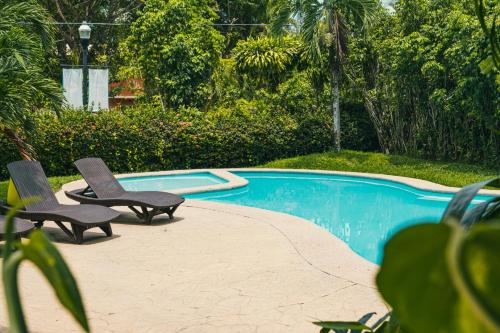 two chairs sitting next to a swimming pool at Hotel Cañada Internacional in Palenque
