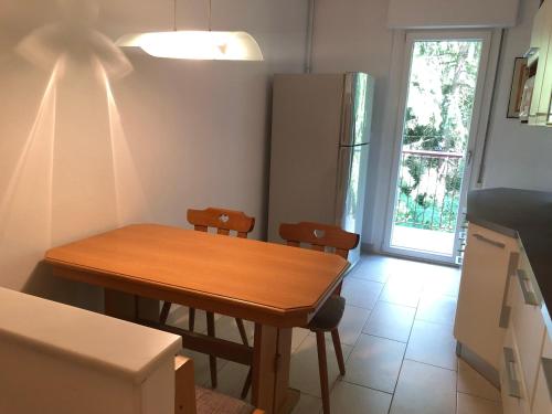 een keuken met een houten tafel en een koelkast bij Guesthouse Gigli 2 - Garage piccolo & Tourist Card in Bolzano