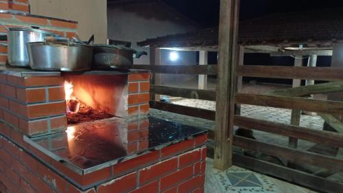 un horno de ladrillo con ollas y sartenes en la parte superior en Pousada Canastra Mineira, en São Roque de Minas