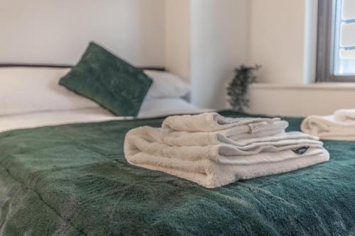 a pile of towels sitting on top of a bed at City centre apartment in Birmingham
