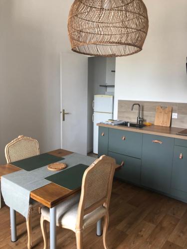 une cuisine avec une table, des chaises et un évier dans l'établissement Étoile de la plage T2 Parking gratuit, à La Ciotat