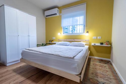 1 dormitorio con 1 cama grande y ventana en נופש ליד הים בת גלים, en Haifa