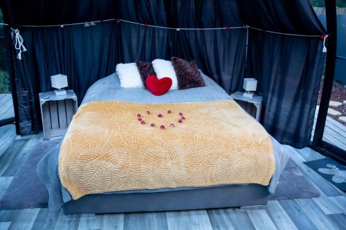 - un lit avec deux oreillers et un cœur dans l'établissement Thudi-nids en bulles, à Gozée