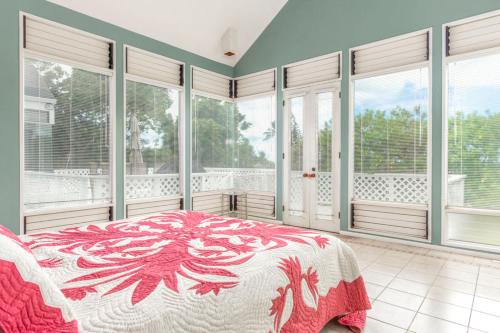 a bedroom with a bed and large windows at The H-House in Waikoloa