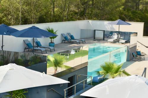 une image d'une piscine avec parasols dans l'établissement Le Meez, à Carcassonne