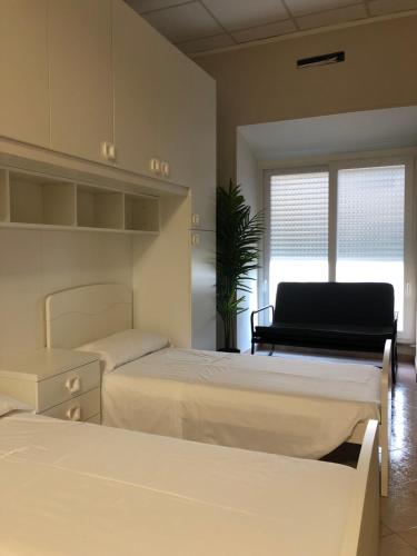 a bedroom with two beds and a window at LA ROMANA AFFITTACAMERE in Colleferro