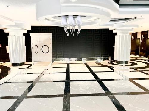 a lobby with a chandelier and a marble floor at Luksusowy apartament z widokiem, basenem i sauną Hanza Tower Szczecin in Szczecin