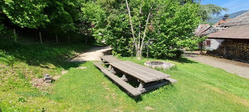 a wooden bench sitting in the grass in a field at Locations des 3 sommets avec Sauna et Spa en Alsace in Sondernach