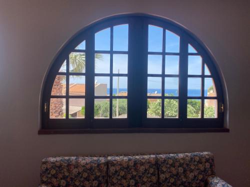 an arched window in a room with a couch at Villa San Vito Bay in Macari