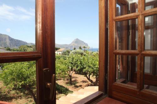 an open glass door with a view of a garden at Villa San Vito Bay in Macari