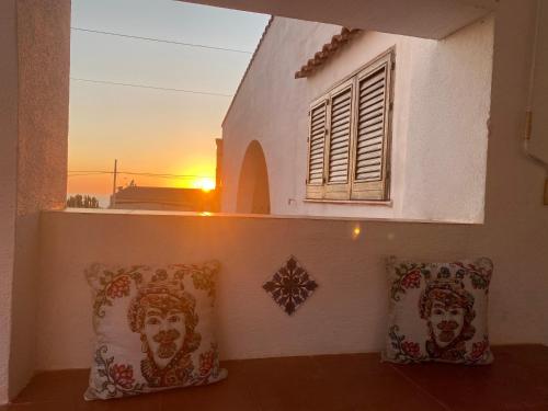 a building with a window and pillows with the sunset at Villa San Vito Bay in Macari