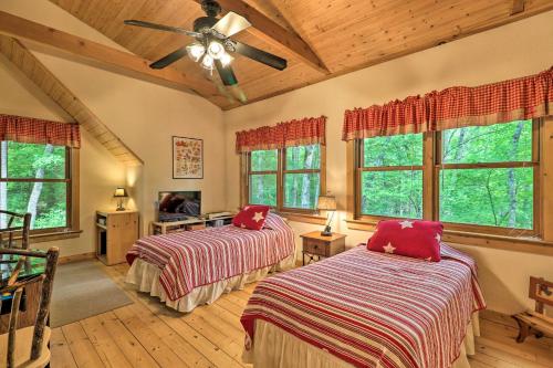 una camera con 2 letti e un ventilatore a soffitto di Woodland Cabin with Hot Tub and Deck 11 Mi to Boone! a Stony Fork
