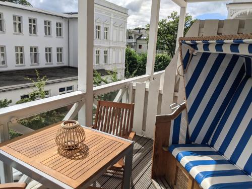 un balcón con mesa y sillas en el porche en DAS APPARTEMENT INSELLIEBE RÜGEN inkl Sauna und 3h täglich Eintritt AHOI Schwimmbad, en Ostseebad Sellin