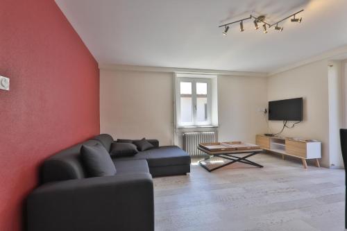 a living room with a couch and a tv at Locations des 3 sommets avec Sauna et Spa en Alsace in Sondernach