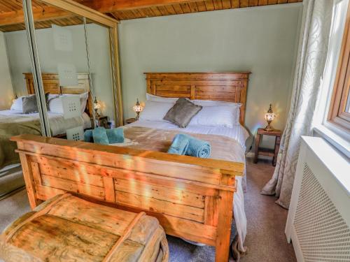 a bedroom with a large wooden bed with a wooden headboard at Lakeside Lodge Retreat in Tattershall