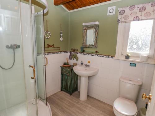 uma casa de banho com um WC, um lavatório e um chuveiro em Lakeside Lodge Retreat em Tattershall