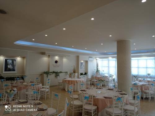 un salón de banquetes con mesas y sillas en una habitación en Villa Corallo Dell'Etna, en Acireale