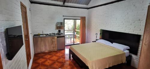 a bedroom with a bed and a kitchen in it at Cálida suite en Liguiqui - Manta in Manta