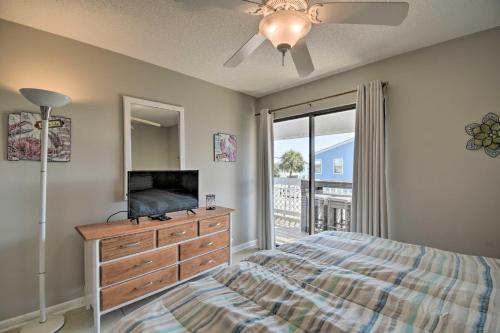 Schlafzimmer mit einem Bett und einer Kommode mit einem TV in der Unterkunft Gulf Shores Condo Private Balcony and Beach Views! in Gulf Shores